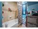 Tiled bathtub with a floral curtain and convenient storage shelves for a functional space at 6100 Bear Paw Rd, Golden, CO 80403