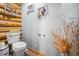 A cozy half-bathroom featuring rustic log wall accents and stylish decor at 6100 Bear Paw Rd, Golden, CO 80403