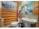 Quaint bathroom with rustic decor, a pedestal sink, and unique design elements at 6100 Bear Paw Rd, Golden, CO 80403