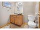 Modest bathroom features a wood vanity, tiled countertop, framed art, and standard fixtures in a neutral color scheme at 6100 Bear Paw Rd, Golden, CO 80403