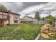 A spacious backyard with a deck, grill, privacy fence, and a stack of firewood at 9374 W Friend Dr, Littleton, CO 80128