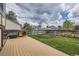 Backyard featuring a wooden deck, a well-maintained lawn, and a privacy fence at 9374 W Friend Dr, Littleton, CO 80128