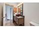 Renovated bathroom with a rustic vanity, stylish fixtures, wood accents, and tiled floor at 9374 W Friend Dr, Littleton, CO 80128