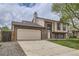 Two story home with brick and neutral siding, a two car garage, and long driveway at 9374 W Friend Dr, Littleton, CO 80128