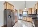 Kitchen featuring wood-look flooring, stainless steel appliances, and wood cabinets at 9374 W Friend Dr, Littleton, CO 80128