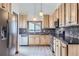 Bright kitchen featuring wooden cabinets, sleek countertops, mosaic backsplash, and stainless steel appliances at 9374 W Friend Dr, Littleton, CO 80128
