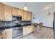 Modern kitchen with stainless steel appliances, wood cabinets, and an open layout at 9374 W Friend Dr, Littleton, CO 80128