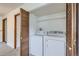 A functional laundry area featuring a washer, dryer, and ample shelving at 9374 W Friend Dr, Littleton, CO 80128