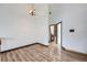 Open loft area with light wood-look floors and view of bathroom at 9374 W Friend Dr, Littleton, CO 80128