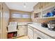Functional laundry room with ample counter space, storage shelves, and a deep utility sink at 916 Griffith St, Georgetown, CO 80444