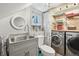 Functional laundry room featuring modern washer and dryer, ample shelving, and a convenient sink area at 916 Griffith St, Georgetown, CO 80444