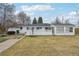 Wide shot of the backyard and the back of the house with an exterior fence, lawn and patio at 3075 S Emerson Way, Englewood, CO 80113
