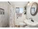 Bright bathroom with modern sink, decorative mirror, and walk-in shower with gray marble style tile surround at 3075 S Emerson Way, Englewood, CO 80113