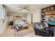 Bedroom featuring a decorative bed frame, tan carpet, built-in bookshelves, and a leather chair at 3075 S Emerson Way, Englewood, CO 80113