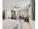 Spacious bedroom with a ceiling fan, exterior windows, and built-in bookshelves, adjacent to the kitchen area at 3075 S Emerson Way, Englewood, CO 80113