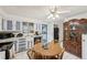 Functional kitchen and dining area with ample cabinet space, a ceiling fan, and white tile flooring at 3075 S Emerson Way, Englewood, CO 80113
