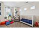 Bright Bedroom with a white crib, cozy chair, and play area, perfect for a growing Gathering at 2936 Merry Rest Way, Castle Rock, CO 80109