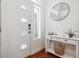 Bright entryway with a white console table, round mirror, and decorative accents on hardwood floors at 2936 Merry Rest Way, Castle Rock, CO 80109