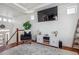 Bright living room features hardwood floors, a cozy chair, mounted television, and staircase at 2936 Merry Rest Way, Castle Rock, CO 80109