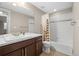 Bright bathroom features a modern vanity, a large mirror, and a shower-tub combo with stylish tile accents at 7903 E 50Th Dr, Denver, CO 80238