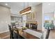 Elegant dining area featuring a modern light fixture, fireplace, and seamless connection to the kitchen and living spaces at 7903 E 50Th Dr, Denver, CO 80238