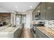A modern kitchen boasts stainless steel appliances, a stylish backsplash, and an island for prep space with a view of wood accent wall at 7903 E 50Th Dr, Denver, CO 80238
