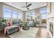 Cozy living room with a plush gray sectional, fireplace, and large windows at 7903 E 50Th Dr, Denver, CO 80238