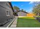 Landscaped backyard with green lawn, stone walkway, and a detached garage with lots of open parking space at 970 S Steele St, Denver, CO 80209
