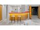 Finished basement bar area with a bright orange bar, bar stools, and stylish lighting at 970 S Steele St, Denver, CO 80209