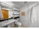 Clean bathroom featuring a pedestal sink, tile floors, and organized shelves for storage at 970 S Steele St, Denver, CO 80209