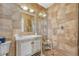 Bathroom features a marble-topped sink, stylish wood cabinet, and seamless glass shower with earth tone tiling at 861 N Humboldt St # A, Denver, CO 80218