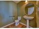 This bathroom features a pedestal sink, wood flooring, and a modern design at 7243 S Millbrook Ct # F, Aurora, CO 80016