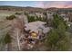 Aerial view of gray house with deck, mountain views, and surrounding trees at 2 Twin Flower, Littleton, CO 80127