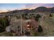 Aerial view of home nestled amongst bare trees, with outdoor fireplace and mountain views at 2 Twin Flower, Littleton, CO 80127