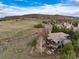 Aerial view of custom home and valley with mountain backdrop and cloudy blue sky at 2 Twin Flower, Littleton, CO 80127