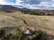 Stunning aerial view of home nestled in lush landscape with mountain views in the background at 2 Twin Flower, Littleton, CO 80127