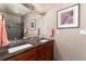 Elegant bathroom with a double vanity, dark wood cabinets, framed art, and contemporary lighting at 2 Twin Flower, Littleton, CO 80127