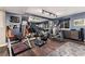 Home gym with a variety of fitness equipment, wood flooring, mirrored wall, and a blue accent wall at 2 Twin Flower, Littleton, CO 80127