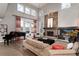 Spacious living room with high ceilings, fireplace, large windows, piano, and hardwood floors at 2 Twin Flower, Littleton, CO 80127