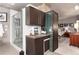 Modern wet bar adjacent to a bathroom and a bedroom with dark wood cabinets, and mini fridge at 2 Twin Flower, Littleton, CO 80127