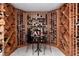 Custom wine cellar with wooden wine racks, tile flooring, and table with two chairs at 2 Twin Flower, Littleton, CO 80127