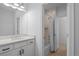 Clean bathroom featuring a white vanity and shower-tub combination at 16202 W 95Th Ln, Arvada, CO 80007