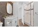 Well-lit bathroom with large mirror, patterned wallpaper, and glass shower at 16202 W 95Th Ln, Arvada, CO 80007