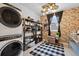 Charming laundry room with patterned walls, storage shelves, and modern appliances at 16202 W 95Th Ln, Arvada, CO 80007