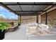 Covered patio with a cozy fire pit, plush seating and manicured landscaping at 16202 W 95Th Ln, Arvada, CO 80007