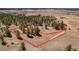 Aerial view of homesite 19 with wooded, grassy lot under a blue sky surrounded by trees and open land at 1555 Arrowpoint Ct, Franktown, CO 80116