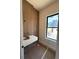 Modern bathroom features floating sink, sleek wood paneling, and natural light from a window at 1555 Arrowpoint Ct, Franktown, CO 80116