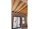 Bedroom under construction with exposed ceiling beams and a large window, offering great natural light at 1555 Arrowpoint Ct, Franktown, CO 80116