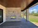 Covered patio with stone fireplace, wood ceiling, and composite decking overlooks a spacious backyard at 1555 Arrowpoint Ct, Franktown, CO 80116