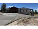 A modern exterior showcasing a wide driveway leading up to a stylish home with stone and wood accents at 1555 Arrowpoint Ct, Franktown, CO 80116